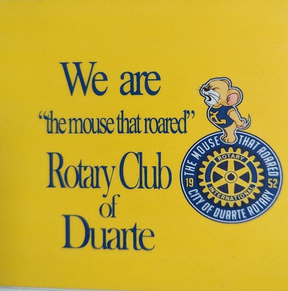 Yellow sign for Rotary Club of Duarte featuring a roaring cartoon mouse and Rotary logo.
